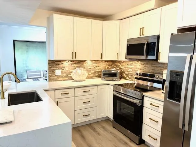a kitchen with stainless steel appliances kitchen island granite countertop a sink stove and refrigerator