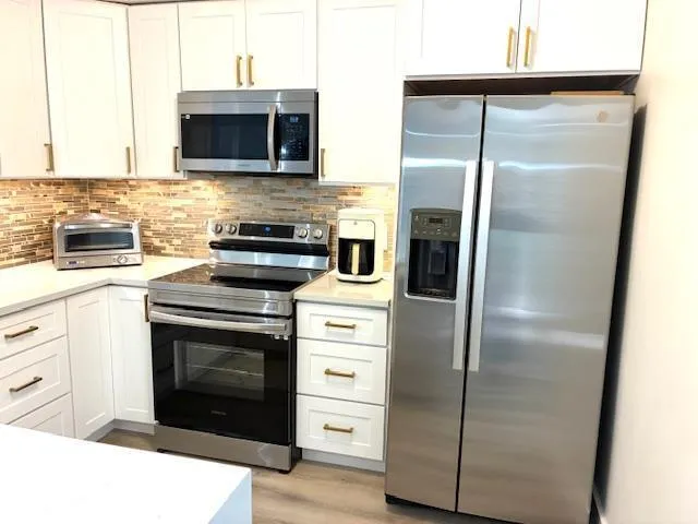 a kitchen with a refrigerator stove and microwave