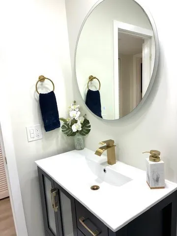 a bathroom with a sink vanity and mirror
