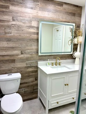 a bathroom with a toilet sink and mirror