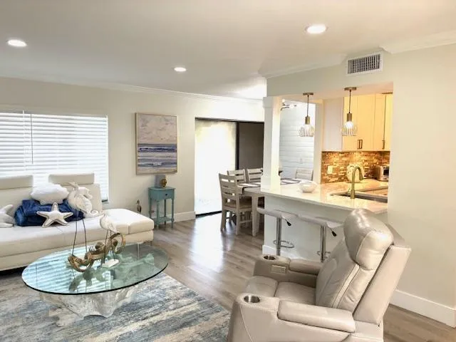 a living room with furniture kitchen and a large window