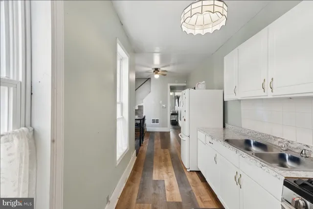 a kitchen with cabinets and wooden floor