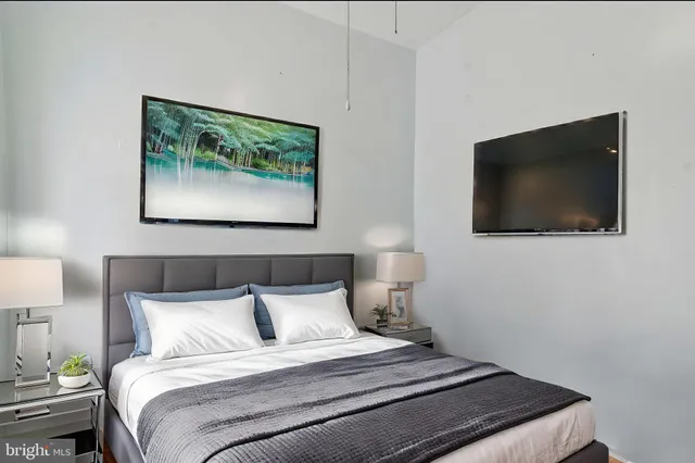 a bedroom with a bed and a flat screen tv