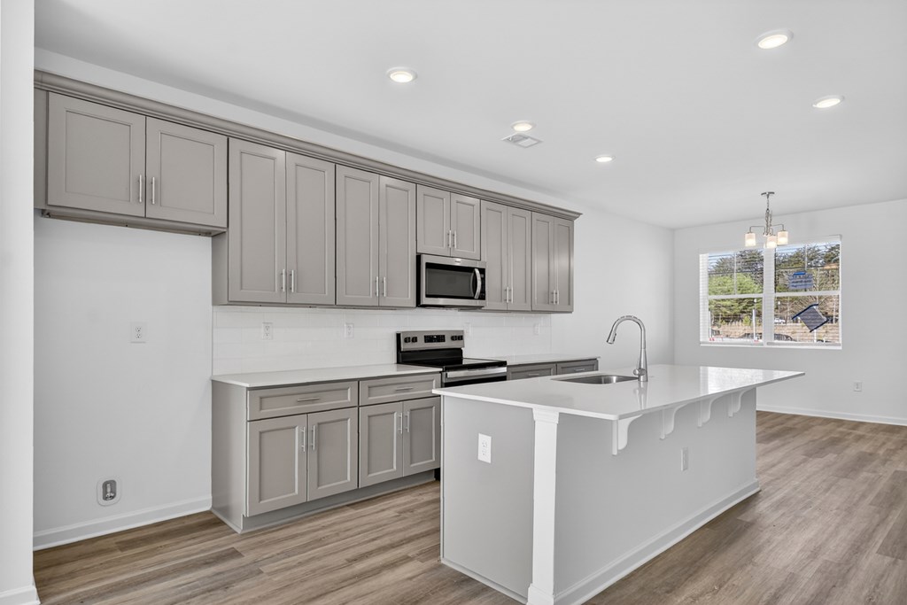 7 Grove Loop Blue Ridge, GA 30513 - Photo 17 of 33 a kitchen with stainless steel appliances granite countertop a sink a microwave a stove and white cabinets with wooden floor