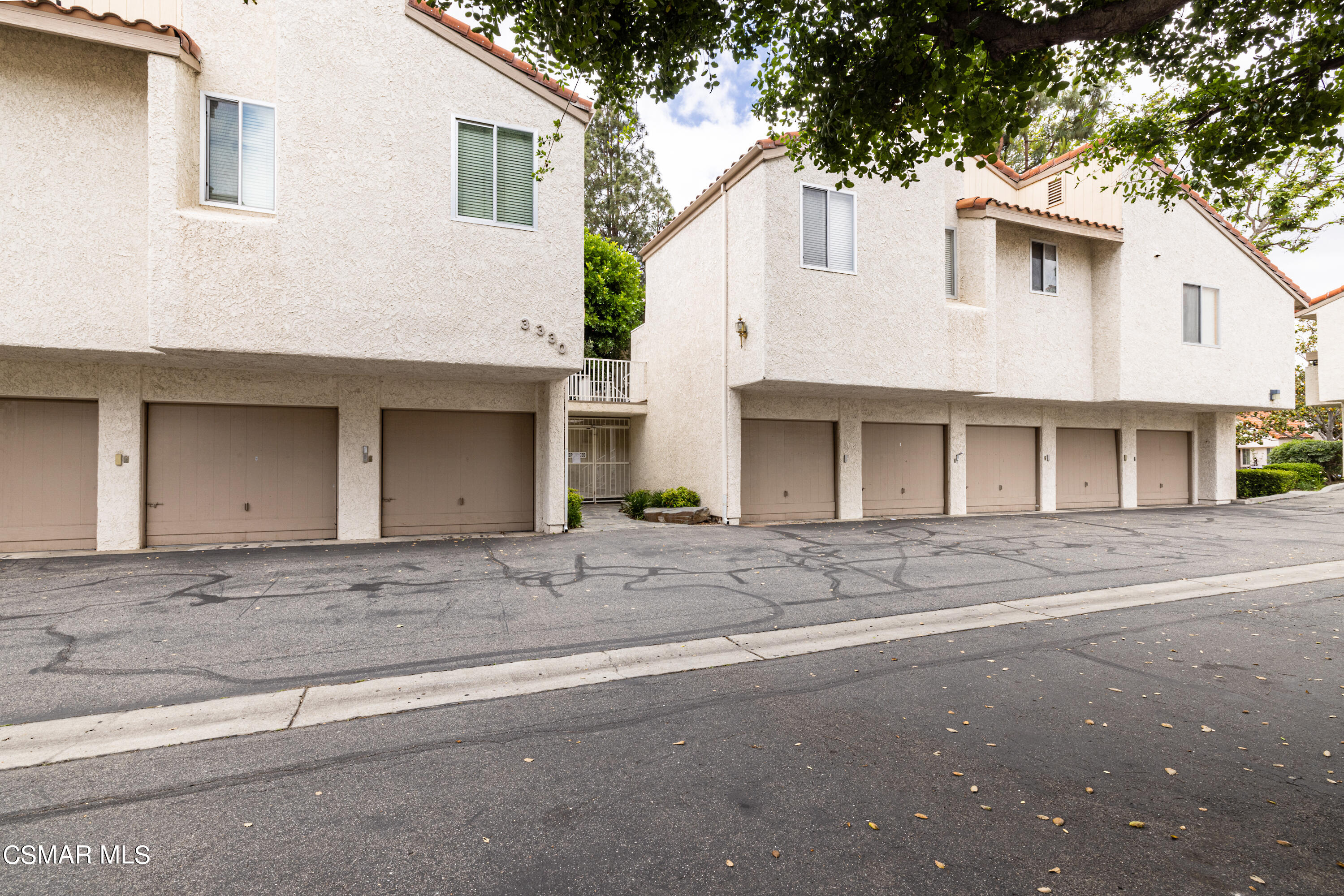 3330 Darby Street, Unit 409 Simi Valley, CA 93063 - Photo 24 of 27 a view of a white house with a large tree
