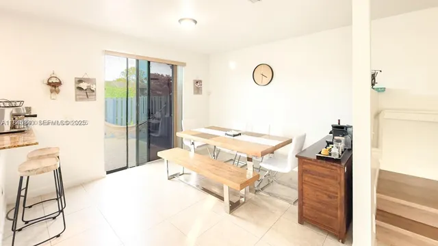 a living room with stainless steel appliances furniture and a kitchen view
