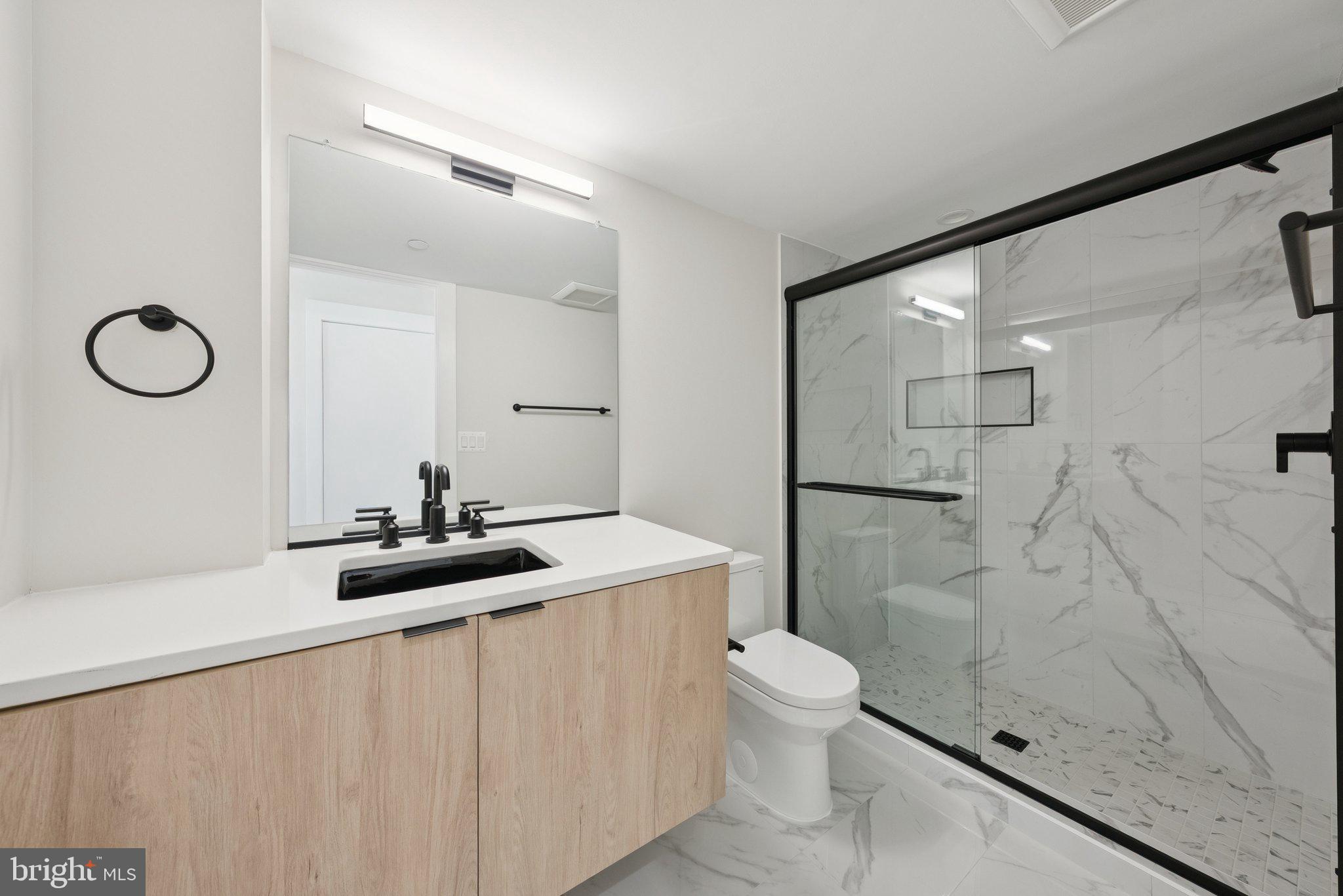 2134 Wisconsin Avenue Northwest, Unit 3 Washington, DC 20007 - Photo 22 of 40 a bathroom with a granite countertop sink a toilet and shower