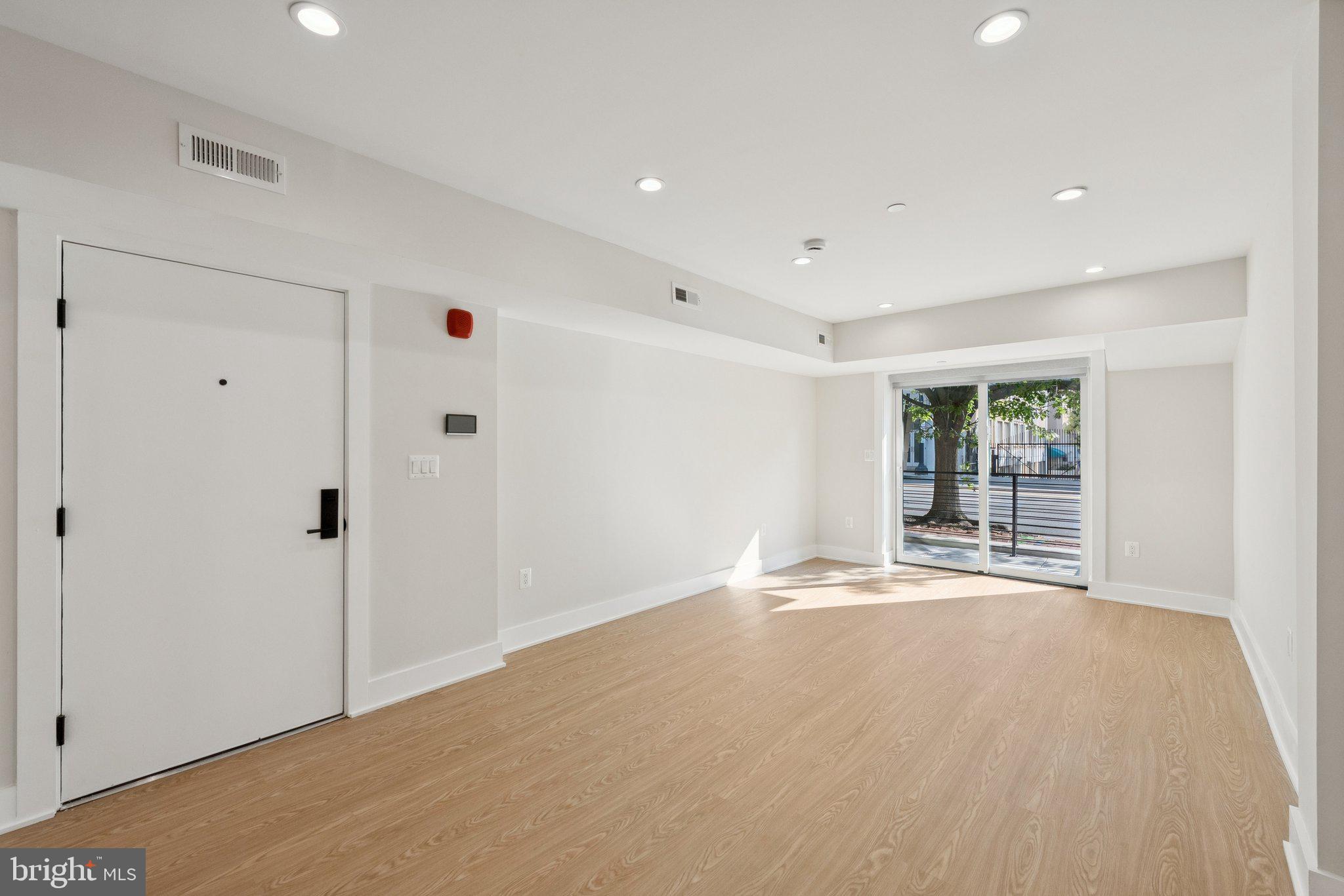 2134 Wisconsin Avenue Northwest, Unit 3 Washington, DC 20007 - Photo 4 of 40 a view of an empty room with wooden floor and a cabinet