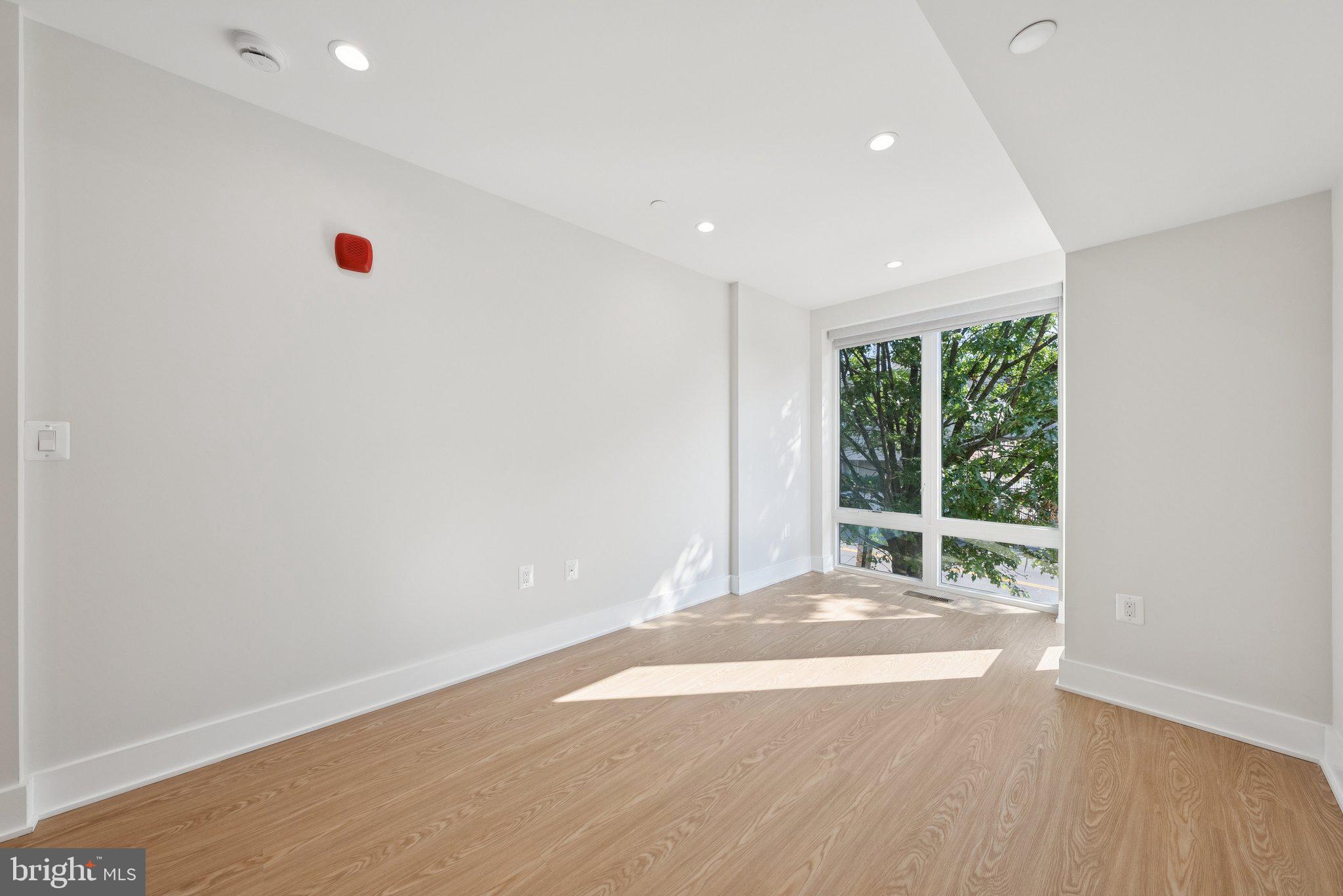 2134 Wisconsin Avenue Northwest, Unit 3 Washington, DC 20007 - Photo 9 of 40 an empty room with wooden floor and windows