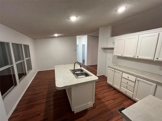 a kitchen with sink cabinets and wooden floor