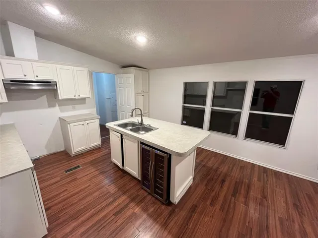 a kitchen with wooden floors and white appliances