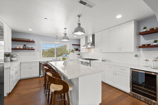 a kitchen with sink a stove and chairs