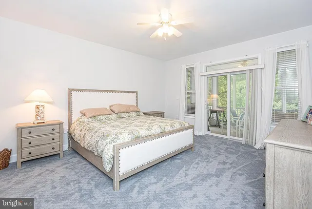 a bedroom with a bed painting on the wall and a window