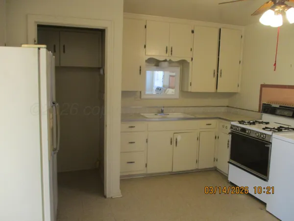 a kitchen with white cabinets and white appliances