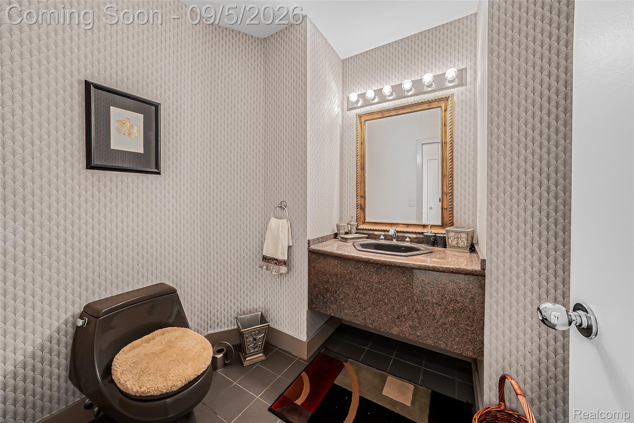 2785 Cranbrook Ridge Court Rochester, MI 48306 - Photo 75 of 97 Powder room featuring a vanity with a stone countertop, an integrated black sink, and a framed mirror with overhead lighting