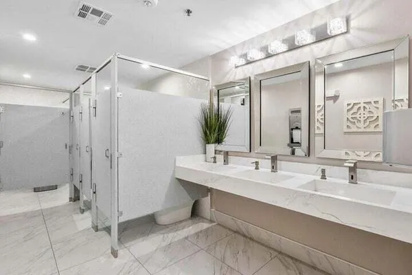 a living room with couches chandelier and kitchen view
