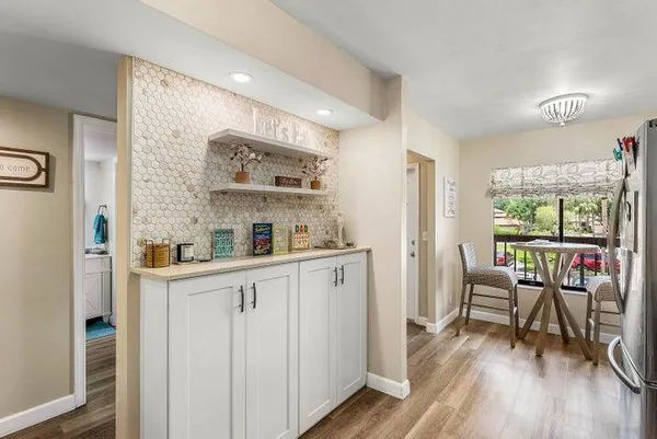 a kitchen with stainless steel appliances white cabinets and wooden floors