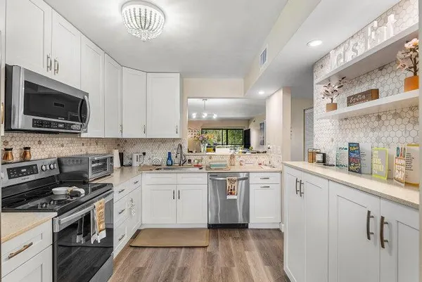a kitchen with granite countertop a sink stainless steel appliances and cabinets