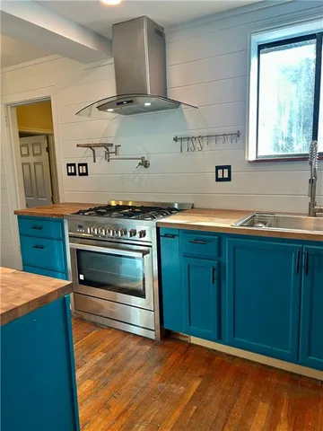a kitchen with stainless steel appliances a stove a sink and a microwave
