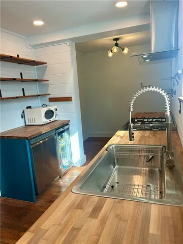 a utility room with stainless steel appliances wooden floor