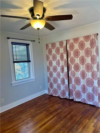 a view of a livingroom with wooden floor and a ceiling fan