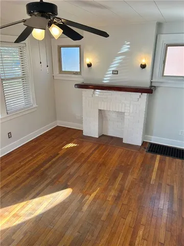 a view of a livingroom with wooden floor and a ceiling fan
