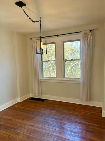 a view of a room with wooden floor and fan