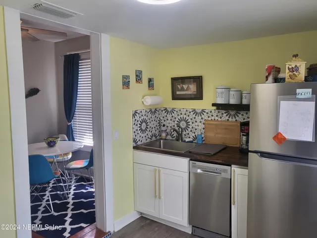a kitchen with stainless steel appliances white cabinets and a stove top oven