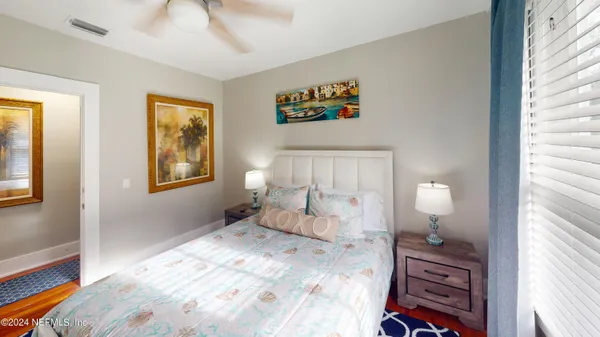 a view of a hallway with wooden floor and a cabinet