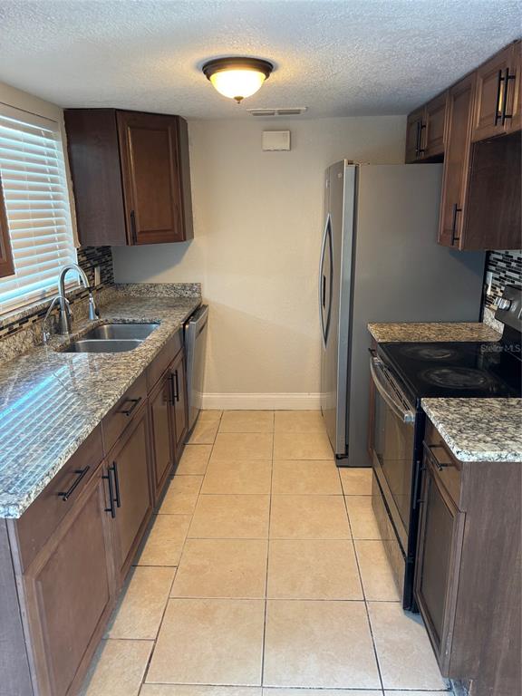 1610 Hinckley Road Orlando, FL 32818 - Photo 10 of 10 a kitchen with a sink a refrigerator and a stove