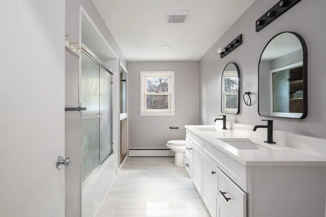 a bathroom with a double vanity sink and a mirror