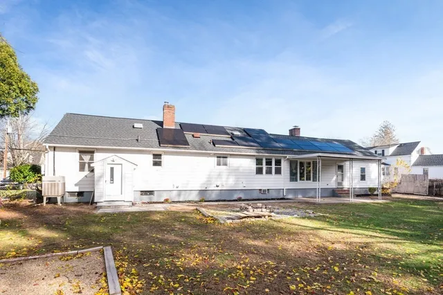 a view of a house with a big yard and large trees
