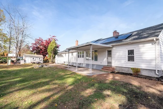a view of a house with backyard and sitting area