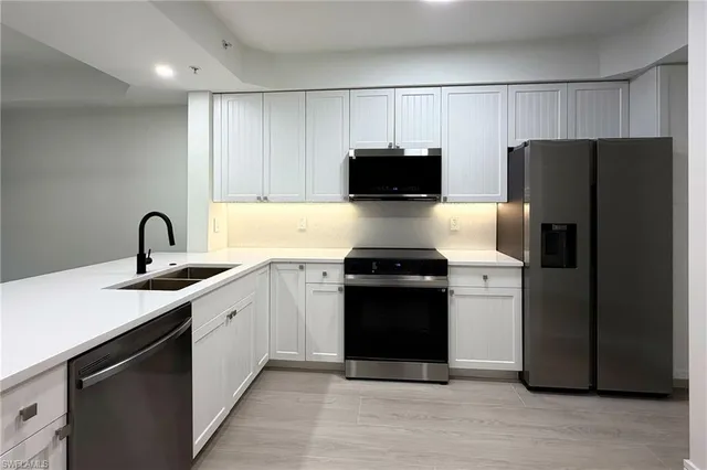 a kitchen with a sink and stainless steel appliances