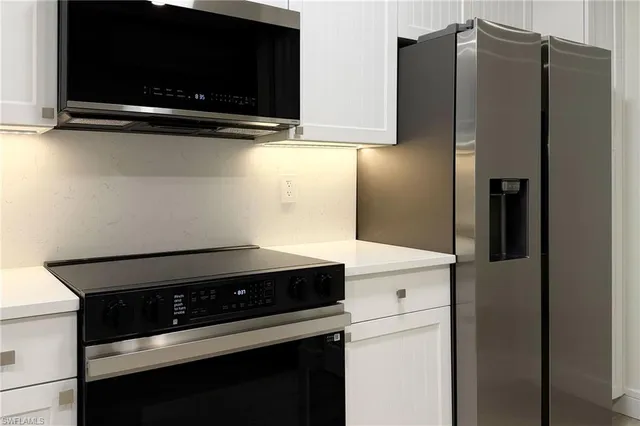 a kitchen with stainless steel appliances a refrigerator and a stove