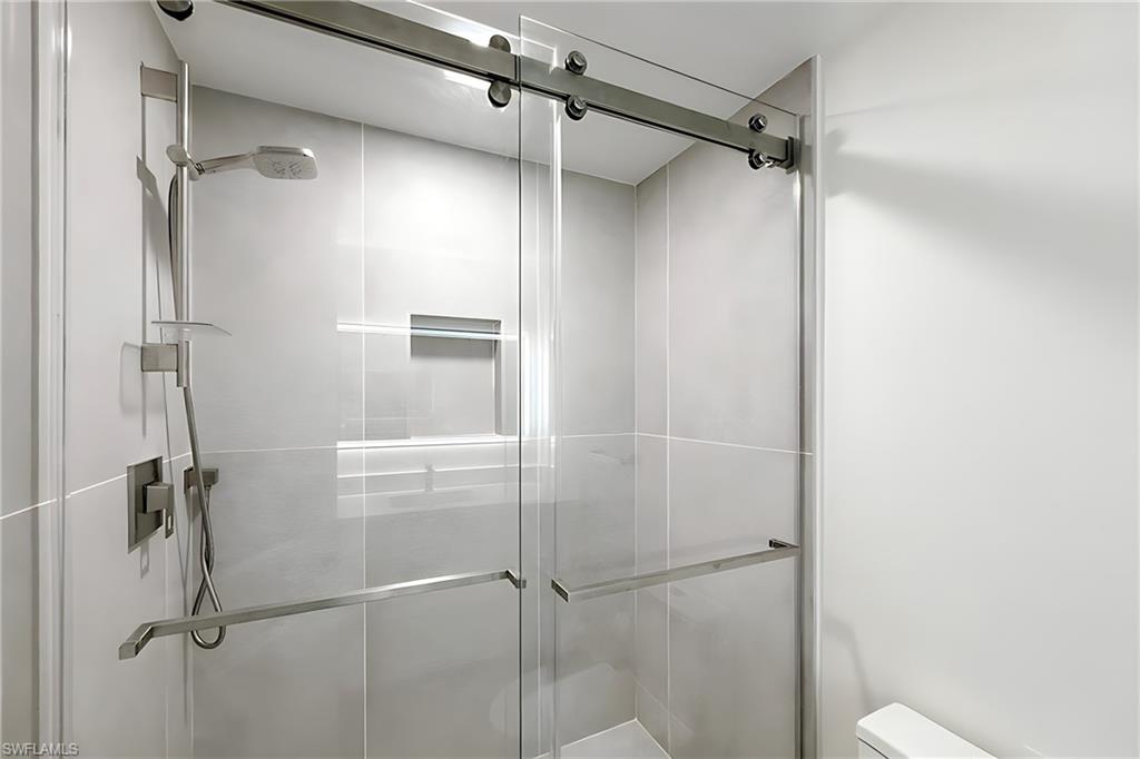 1100 Pine Ridge Road, Unit A106 Naples, FL 34108 - Photo 16 of 27 a bathroom with a glass shower door