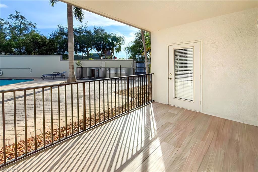 1100 Pine Ridge Road, Unit A106 Naples, FL 34108 - Photo 20 of 27 a view of a porch with wooden floor and fence