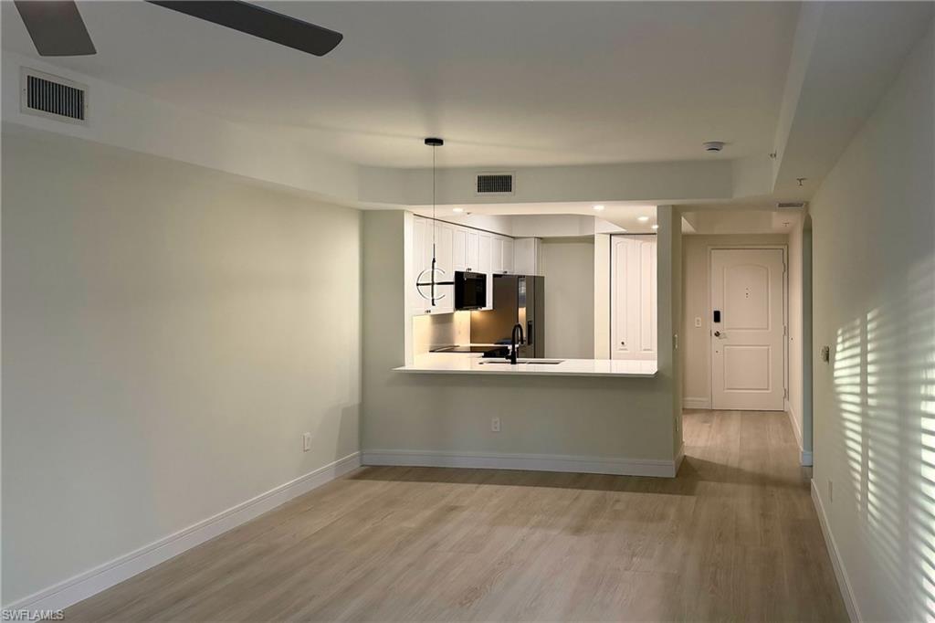1100 Pine Ridge Road, Unit A106 Naples, FL 34108 - Photo 2 of 27 a view of a kitchen with a sink and wooden floor