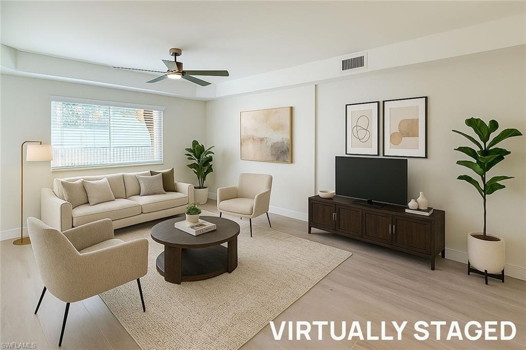 1100 Pine Ridge Road, Unit A106 Naples, FL 34108 - Photo 5 of 27 a living room with furniture and a flat screen tv