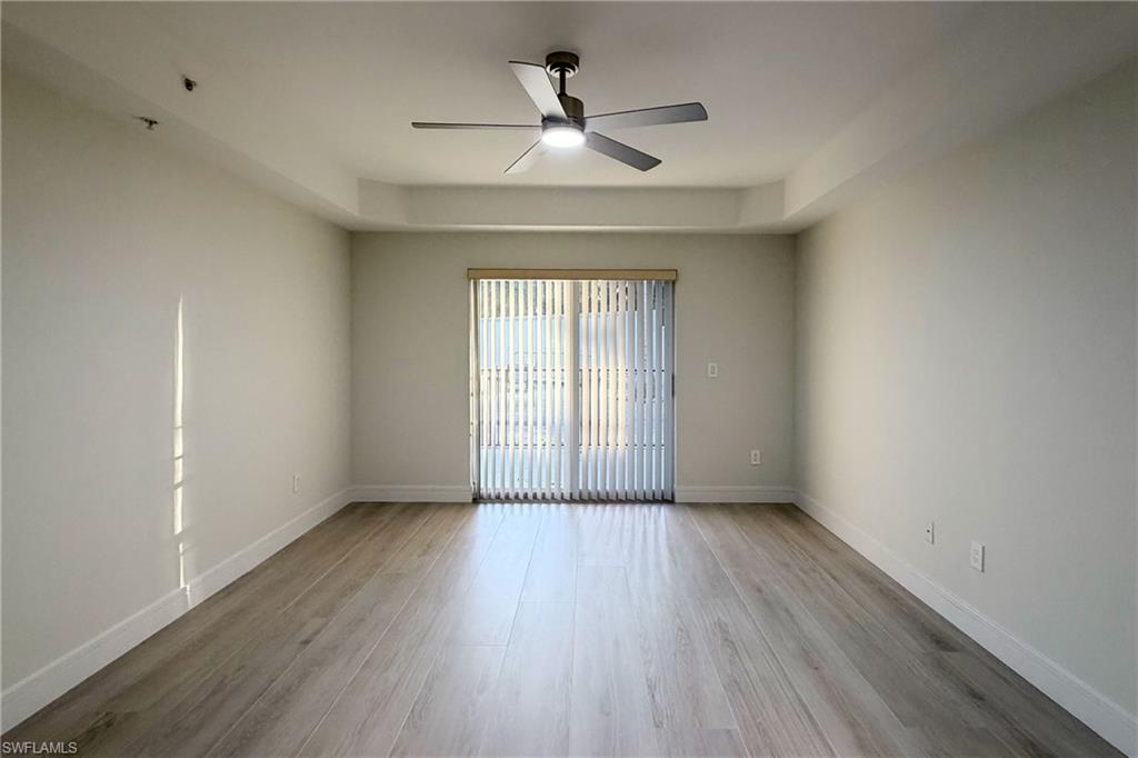 1100 Pine Ridge Road, Unit A106 Naples, FL 34108 - Photo 10 of 27 wooden floor in an empty room with a window