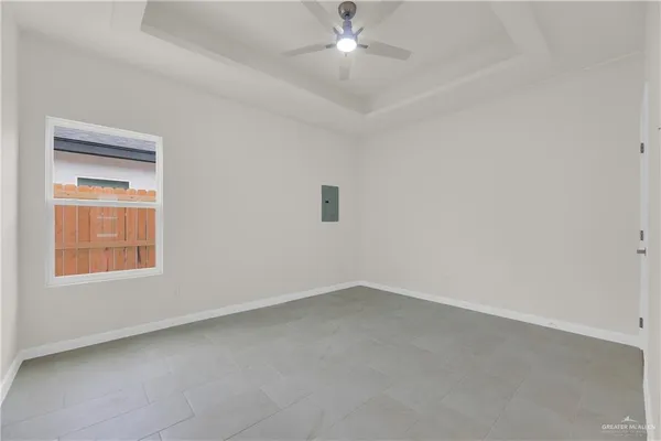 an empty room with a window and a fan