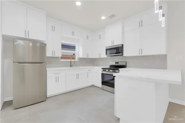 a kitchen with a refrigerator stove and microwave