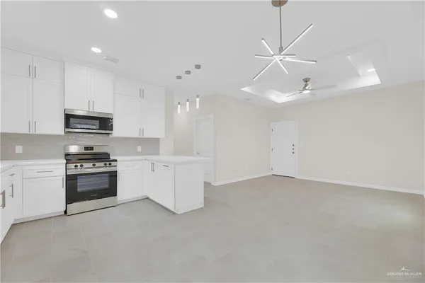 a kitchen with stainless steel appliances kitchen island a white cabinets and stove top oven