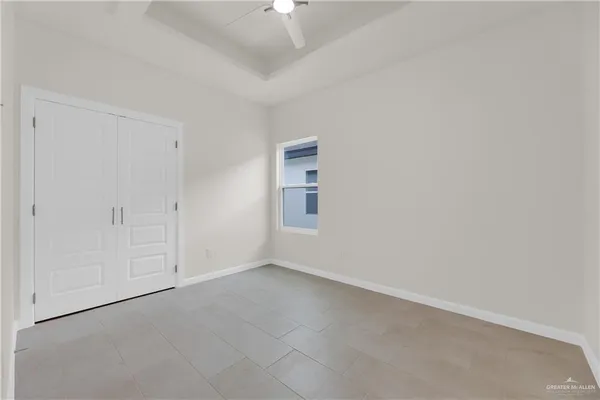a view of an empty room and chandelier fan