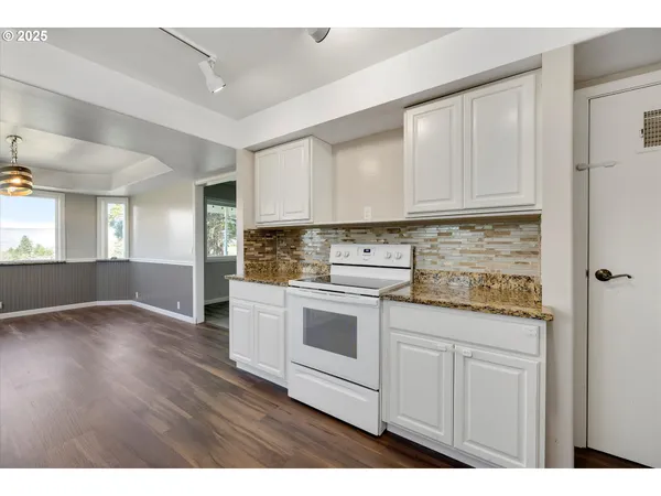 a kitchen with granite countertop white cabinets and white appliances