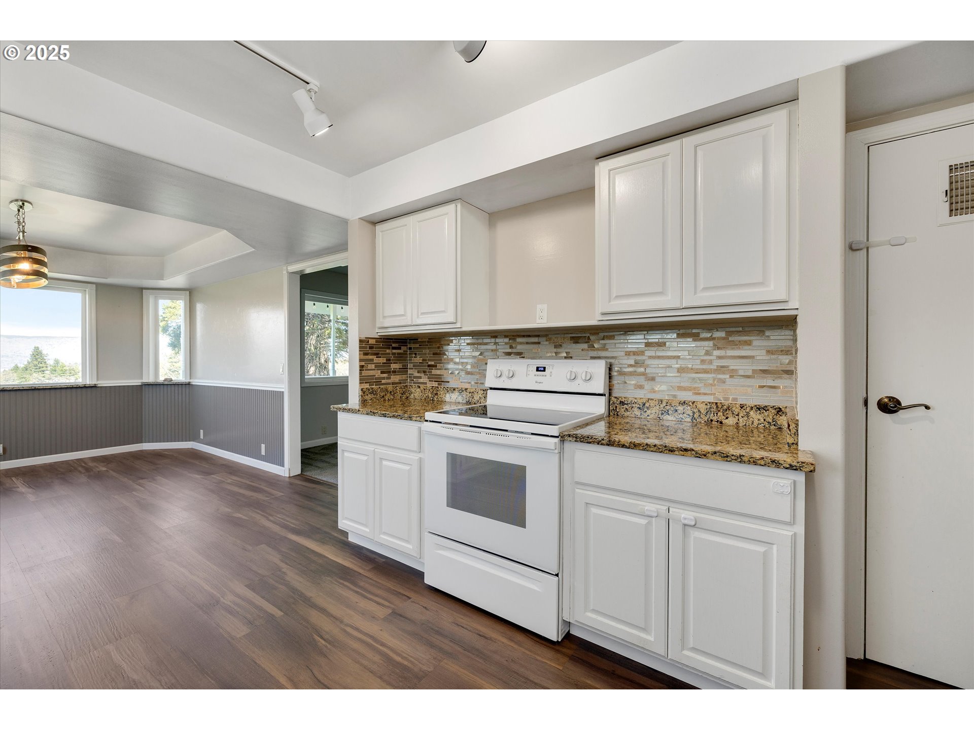 1805 Carroll Road Mosier, OR 97040 - Photo 19 of 45 a kitchen with granite countertop white cabinets and white appliances