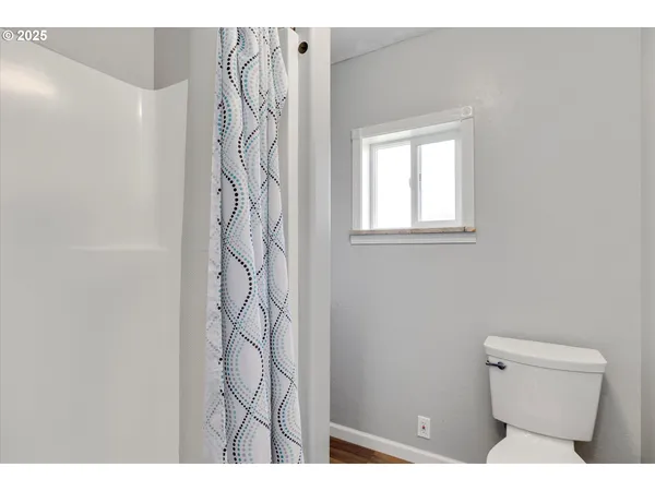 a bathroom with a toilet and a shower curtain