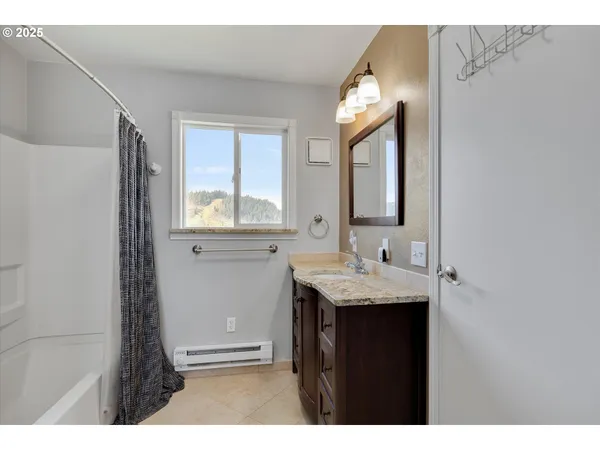 a bathroom with a granite countertop sink mirror and a window