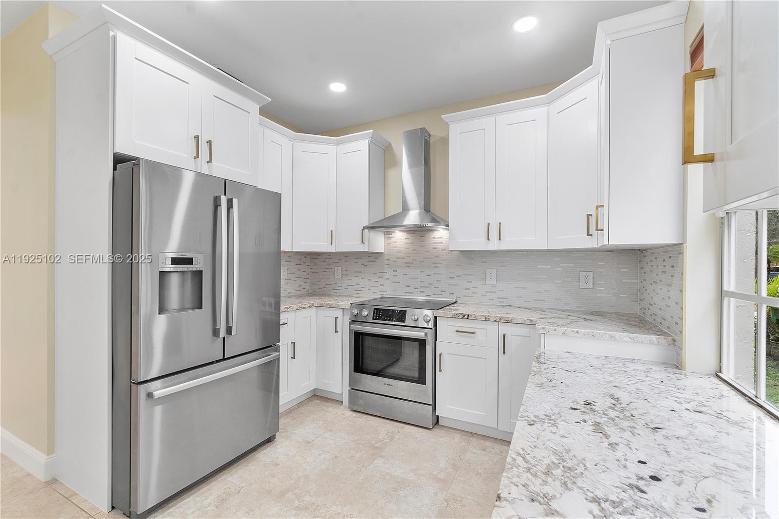 a kitchen with stainless steel appliances granite countertop a refrigerator a stove and a sink