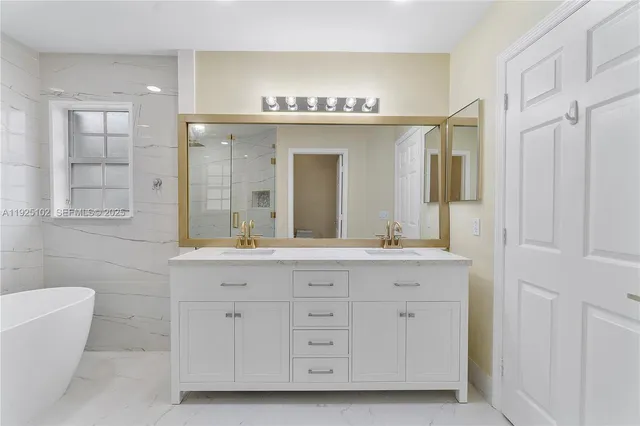 a spacious bathroom with a granite countertop sink mirror and bathtub
